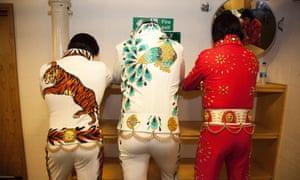 A trio of Elvis impersonators show off their customised outfits.